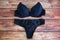 Black bras and panties on wooden background