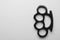 Black brass knuckles on white background, top view. Space for text