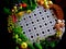 Black bread, fruits and vegetables on a round table covered with a crocheted linen openwork tablecloth