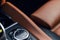 Black and brown leather car interior. Modern car illuminated dashboard. Luxurious car instrument cluster. Close up shot of instrum