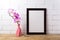 Black brown poster frame mockup with pink orchid