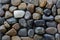 Black brown stones with one white pebbles standing out between d