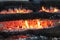 Black burning smoldering coals and orange fire
