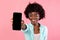 Black Bushy Lady Showing Phone Screen Over Pink Background