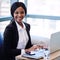 Black businesswoman smiling at the camera in front of computer