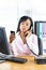 Black businesswoman using two phones at desk