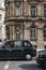 Black cabs in front of a building on Queen Victoria street in City of London, UK.