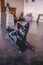 Black canine lying on the floor, gazing towards the camera with a contemplative expression