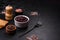 Black, canned beans in a white saucer against a dark concrete background