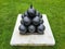 black cannonballs in pyramid stack on cement on grass