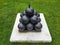 black cannonballs in pyramid stack on cement on grass