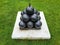 black cannonballs in pyramid stack on cement on grass