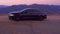 Black Car Audi A6 with driving on mountains road during sunset and mountains in background low light shot. Highway in the mountain