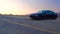 Black Car Audi A6 with driving on mountains road during sunset and mountains in background low light shot. Highway in the mountain