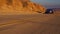 Black car Audi A6 with driving on mountains road during sunset and mountains in background low light shot. Highway in the mountain