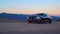 Black Car Audi A6 with driving on mountains road during sunset and mountains in background low light shot. Highway in the mountain