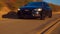 Black Car Audi A6 with driving on mountains road during sunset and mountains in background low light shot. Highway in the mountain