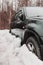 black car parked in snowdrift. Auto covered in snow. Wheel stuck in the deep snow