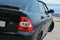 A black car by the river. Side black car, parked in the recreation area by the river.