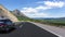 Black car rushes along the road against the backdrop of a beautiful countryside landscape.