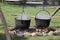 Black cast iron cooking pots steaming over fire