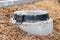 A black cast-iron sewer hatch on a concrete base, located on a mound of damp ground for access to the sewer well