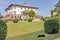 A black cat on the grass with the Medici villa of Poggio a Caiano in the background, Prato, Italy