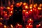 a black cat sitting in front of a bunch of candles