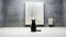 A black cat sitting in front of a white wall