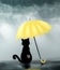 Black cat under yellow umbrella