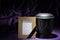 Black cemetery urn with blank natural wooden mourning frame, on deep purple background