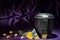 Black cemetery urn with candles yellow rose and dark green ribbon on deep purple background