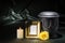 Black cemetery urn with golden mourning frame burning candle and yellow rose on dark green background