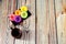 A black ceramic plate with five donuts in multi-colored glaze and a cup of black fresh coffee on a wooden table