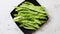 Black ceramic plate with fresh green bean pods