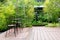 Black chair in wood patio at green garden with fountain in house