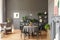 Black chairs at round table under lamp in grey loft interior wit