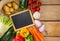 Black Chalk Board  with Assorted Organic Veggies on Sides on Top of Wooden Table