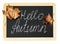 Black chalkboard with golden maple leaves and lettering Hello Autumn