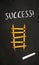 Black chalkboard with a ladder made of pencils and the word Success