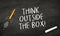 Black Chalkboard with rocket pencil and message Think outside the box