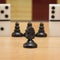 Black chess knight on the background of pawns and dominoes