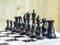 Black chess pieces are in the correct order on the chess board. Staunton chess set. Close-up