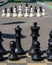 Black chess set standing on asphalt road