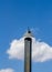 Black chimney with a blue sky and a white cloud