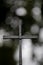 Black christian cross in front of blurry bokeh