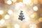 Black christma tree outline on gold, yellow, white, black, and grey color bokeh background.