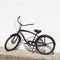 Black city bicycle cruiser standing by next white wall