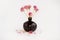 Black clay pomegranate on a white background. original vase in the form of a pomegranate. dried flowering onions with