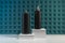 Black clean cosmetic containers on the podium against abstract green wall background. Blank bottle packaging, branding